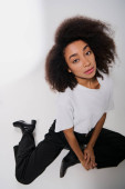 good looking african american female model sitting on floor and looking at camera, fashion concept Longsleeve T-shirt #697415222