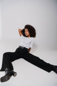 beautiful african american female model sitting on floor and looking at camera, fashion concept mug #697415354