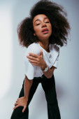 appealing african american woman in chic attire with curly hair looking at camera, fashion concept Sweatshirt #697415860