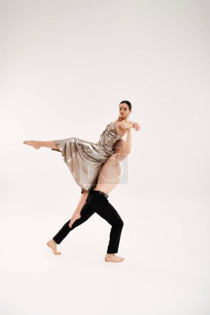Shirtless joven hombre y mujer en vestido brillante ejecutando movimientos acrobáticos de baile sobre fondo blanco