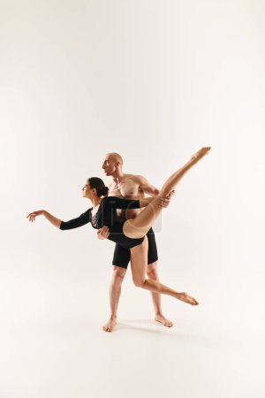 Shirtless young man and woman dance in mid-air, executing acrobatic moves in a studio setting against a white backdrop.