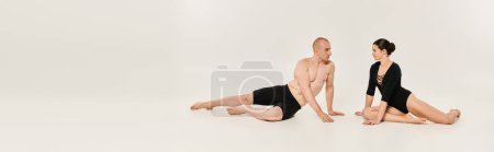 Photo for A shirtless young man and a young woman dancing in a couple and looking each other on the ground. - Royalty Free Image