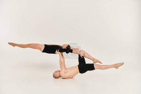 Shirtless young man and woman dancing and performing acrobatics.