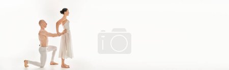 Photo for Shirtless young man and a woman in a white dress perform acrobatic elements in a dance routine. - Royalty Free Image