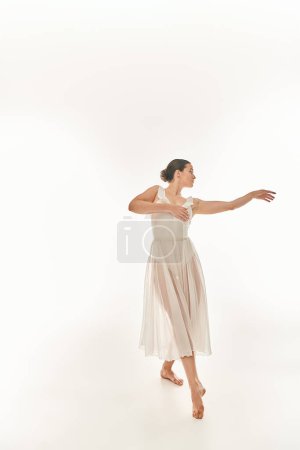 Young woman in elegant white dress twirls while holding a white frisbee, against a white background.