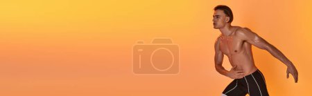 Téléchargez les photos : Beau jeune homme athlétique posant seins nus dans des mouvements actifs sur fond orange vif, bannière - en image libre de droit
