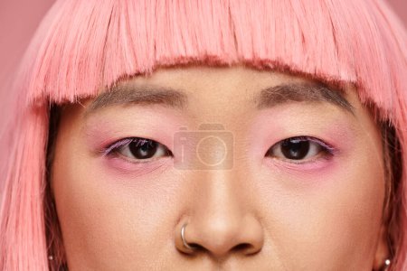 close up of confident asian young woman, female eyes with nose piercing, pink hair and makeup