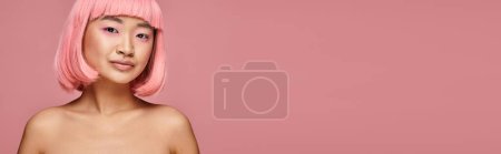 Téléchargez les photos : Bannière de attrayant asiatique femme dans son 20s avec des cheveux roses et maquillage sur fond vibrant - en image libre de droit