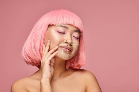 asian woman with pink hair and closed eyes touching her cheek on vibrant background