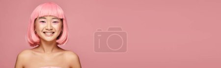 Photo for Horizontal shot of happy and charming asian girl with pink hair and makeup on vibrant background - Royalty Free Image
