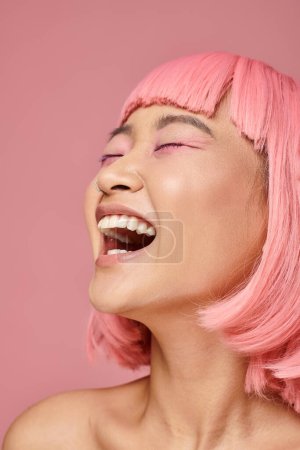 Photo for Asian woman in her 20s with pink hair and makeup laughing against vibrant background - Royalty Free Image