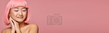 Photo for Horizontal shot of cute asian woman with pink hair looking to down with hands on vibrant background - Royalty Free Image