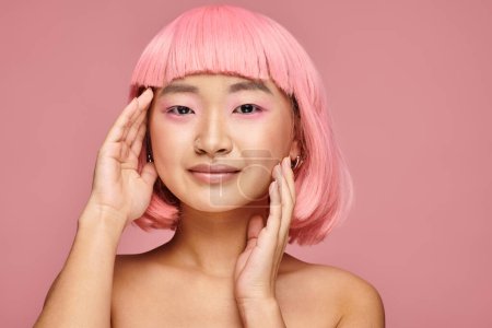 Téléchargez les photos : Charmante asiatique femme dans son 20s avec nez piercing posant avec les mains sur fond vibrant - en image libre de droit