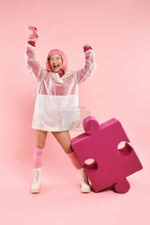 Photo for Happy asian woman in 20s in stylish outfit playing to joystick and wining on vibrant background - Royalty Free Image