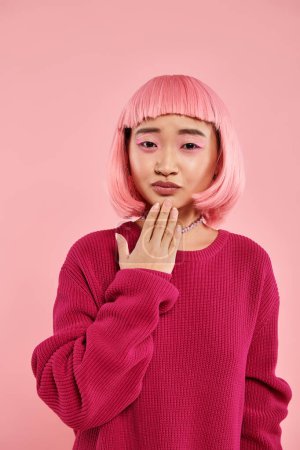 Photo for Lovely asian young woman with pink hair and pearl necklace in vibrant sweater sympathizing - Royalty Free Image