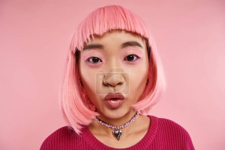 Nahaufnahme schöne asiatische Frau in den 20ern mit Nasenpiercing und rosa Haaren überrascht und schaut in die Kamera