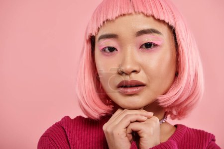 Foto de Primer plano asiático mujer en 20s con rosa maquillaje y doblado manos contra vibrante fondo - Imagen libre de derechos