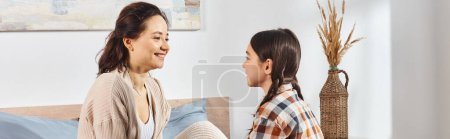 Une mère et sa fille discutent dans une chambre chaleureuse et accueillante.