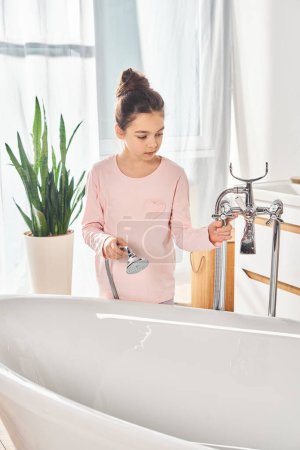 A brunette girl stand in front of a sink in a modern bathroom, engaging in beauty and hygiene routine.