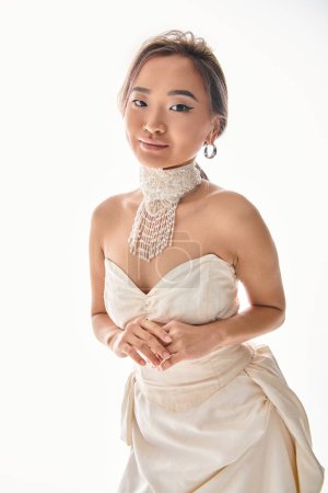 Charmante junge Frau mit Raffinesse Halskette zurückhaltend posiert auf weißem Hintergrund