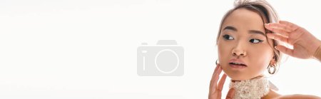 Photo for Banner of alluring asian woman with grace white necklace posing with hands on white background - Royalty Free Image