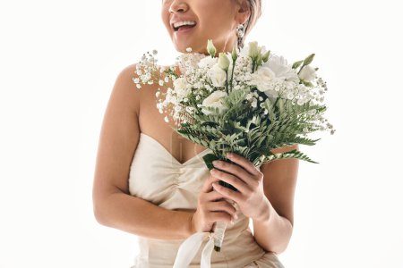 abgeschnittene Aufnahme einer lächelnden jungen Frau mit weißem Blumenstrauß vor hellem Hintergrund