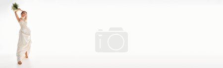 Téléchargez les photos : Plan horizontal de femme asiatique en robe blanche sur le point de jeter bouquet de fleurs en arrière-plan clair - en image libre de droit