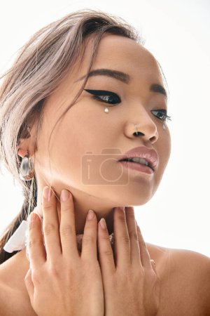 Téléchargez les photos : Gros plan de belle mariée asiatique avec élégant maquillage regarder sur le côté et étreindre le cou avec les mains - en image libre de droit