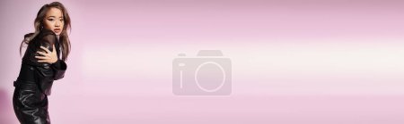 Photo for Banner of charming young woman in black leather outfit hug herself sideways on lilac background - Royalty Free Image