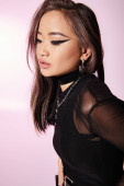 charming asian woman in 20s with heavy makeup looking to back against lilac background Poster #698338076