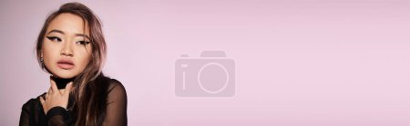 Photo for Banner of asian woman in her 20s with brown hair looking to side and touching to neck with hand - Royalty Free Image