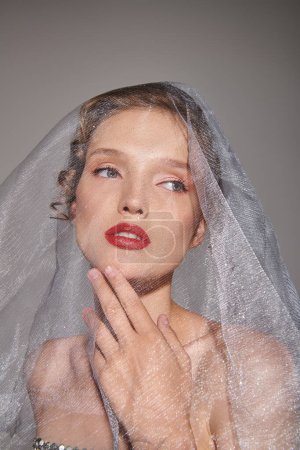Téléchargez les photos : Une jeune femme respire la beauté classique dans un portrait en studio avec un voile drapé sur la tête. - en image libre de droit