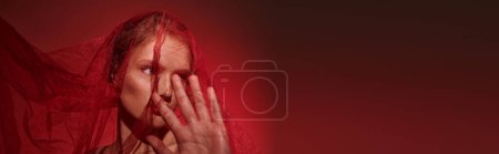Photo for A young woman, embodying classic beauty, covers her face with her hands in a poignant gesture. - Royalty Free Image