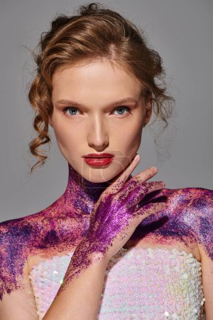 Eine junge Frau mit klassischer Schönheit posiert in einem Atelier, ihr Körper ist mit leuchtend lila Farbe verziert und strahlt eine elegante Aura aus.