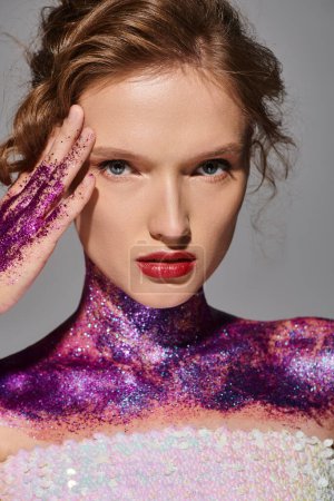 A young woman with classic beauty poses in a studio, her body sparkling with purple and pink glitter.