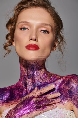 Eine junge Frau mit klassischer Schönheit posiert in einem Studio-Setting, ihr Körper ist in hypnotisierenden Violettönen lackiert.
