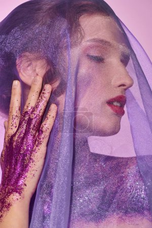 A young woman exudes classic beauty as she poses in a studio setting, her face delicately adorned with purple makeup and a veil covering her head.