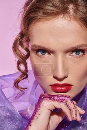 Une jeune femme aux yeux bleus captivants respire la beauté classique dans un décor de studio, élégamment ornée d'une robe violette saisissante.