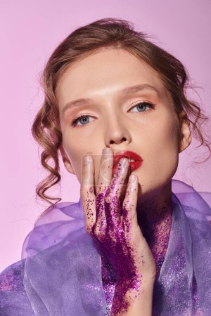 A classic beauty with purple paint-stained hands poses artistically in a studio setting.