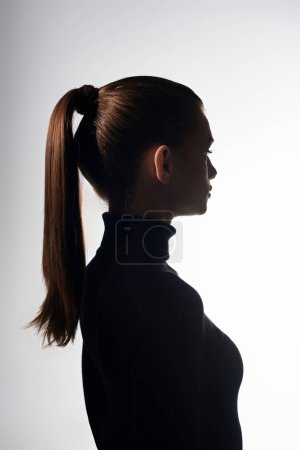 Attractive woman with long hair styled in a ponytail, radiating grace and elegance.