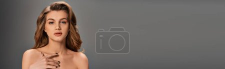 Photo for A young beautiful woman with long wavy hair striking a pose for a picture, banner. - Royalty Free Image