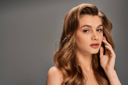 Photo for A young woman with long brown wavy hair strikes a pose for the camera. - Royalty Free Image