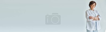 Téléchargez les photos : Femme gaie d'âge moyen debout avec les bras croisés et regardant la caméra avec le sourire, bannière - en image libre de droit
