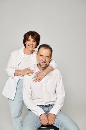 Photo for Portrait of middle aged man and woman looking at camera and smiling on grey background - Royalty Free Image