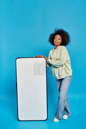 Téléchargez les photos : Une femme se tient en confiance à côté d'un tableau blanc massif, prête à partager des idées et à inspirer la créativité. - en image libre de droit