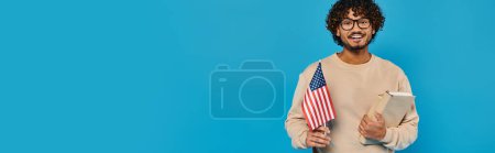 Un homme en tenue décontractée tient un presse-papiers avec un drapeau américain en arrière-plan, montrant patriotisme et organisation.