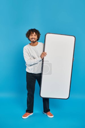 Ein Mann verschiedenster Herkunft steht vor blauem Hintergrund und hält eine große weiße Tafel vor sich..