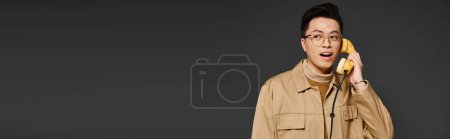 Téléchargez les photos : Un jeune homme à la mode en tenue élégante tient ludique smartphone - en image libre de droit