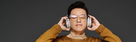 Photo for A fashionable young man wearing glasses and headphones, actively engaged in posing. - Royalty Free Image