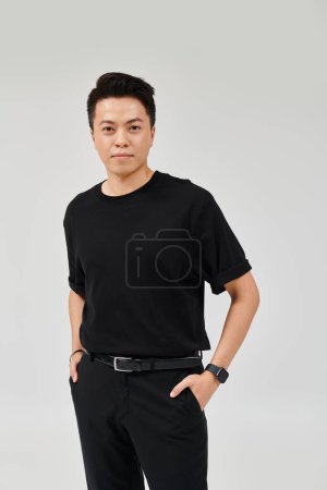 Photo for A fashionable young man in elegant attire striking a confident pose with his hands resting on his hips. - Royalty Free Image